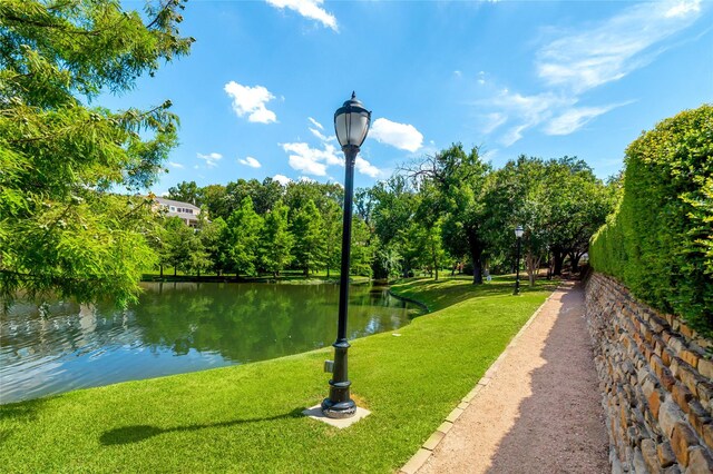 surrounding community with a water view and a yard