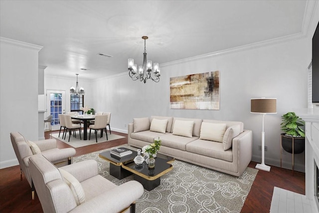 living room with dark hardwood / wood-style floors, an inviting chandelier, and ornamental molding