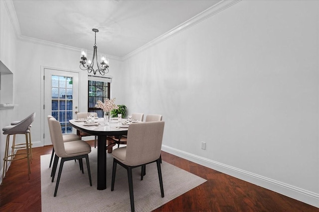 dining room with a notable chandelier, ornamental molding, and dark wood-type flooring