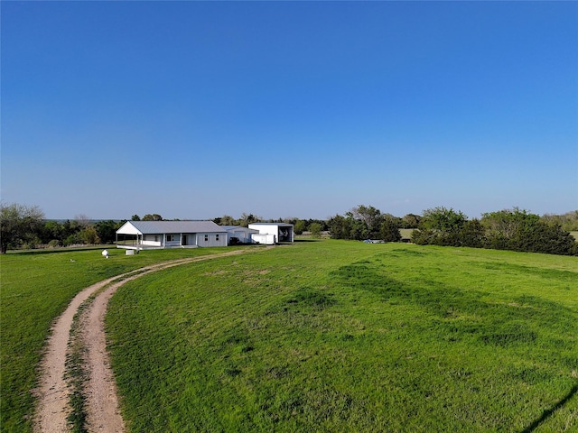 view of yard featuring a rural view and dirt driveway