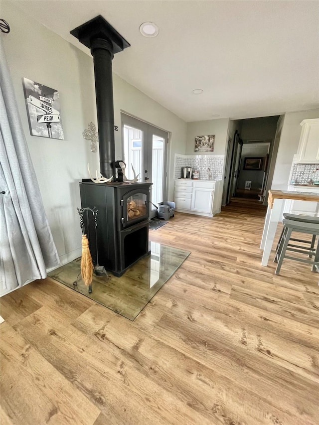 living room featuring light hardwood / wood-style flooring and a wood stove