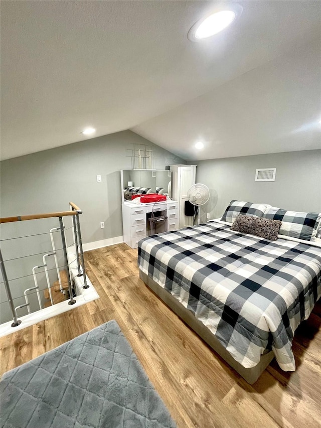 bedroom featuring lofted ceiling and light hardwood / wood-style flooring