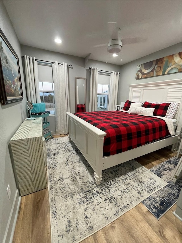 bedroom featuring multiple windows, ceiling fan, and light hardwood / wood-style floors