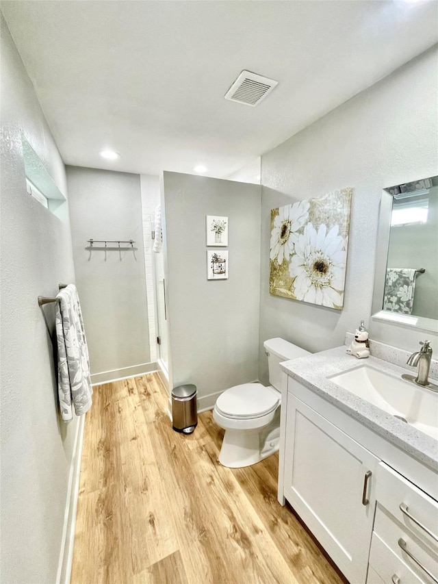 bathroom featuring vanity, hardwood / wood-style floors, and toilet