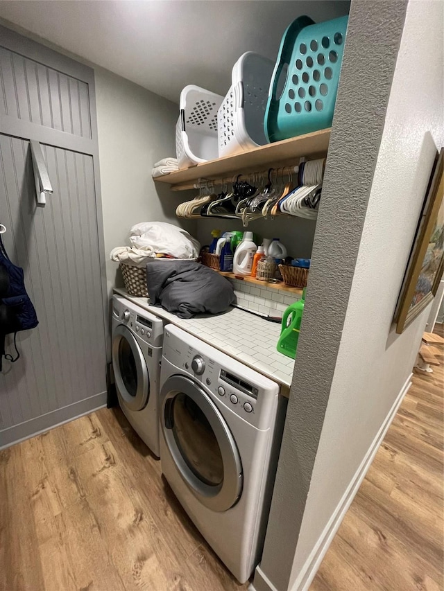 laundry room featuring separate washer and dryer and light hardwood / wood-style flooring