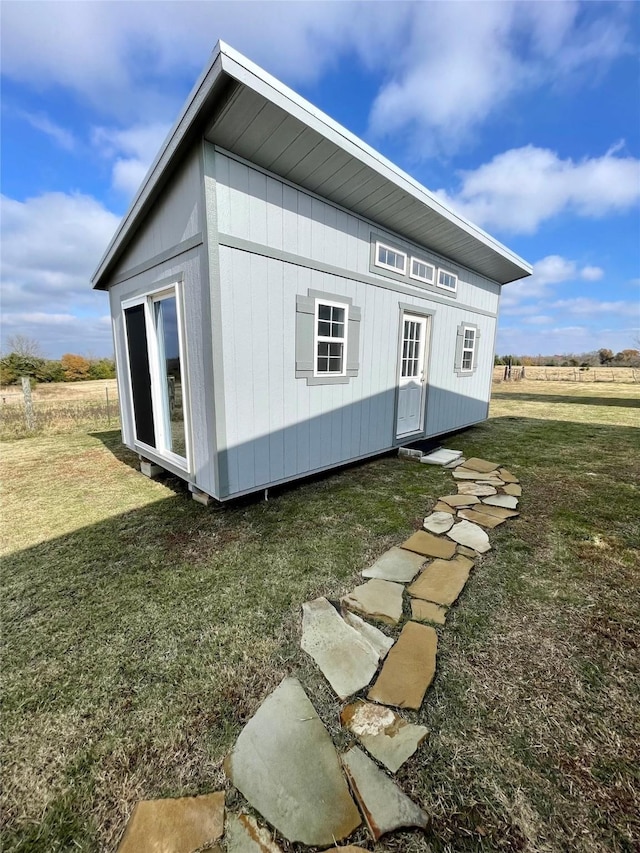 view of home's exterior featuring a yard and an outbuilding