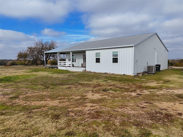 back of property featuring central AC, a lawn, and a porch