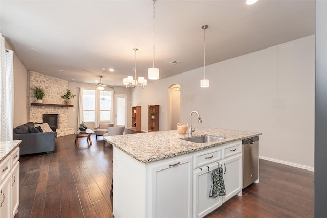 kitchen with sink, dark wood-type flooring, stainless steel dishwasher, an island with sink, and white cabinets