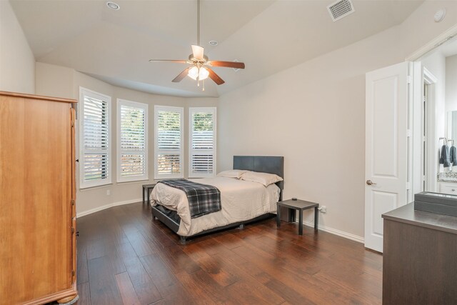 bedroom with dark hardwood / wood-style floors, vaulted ceiling, and ceiling fan