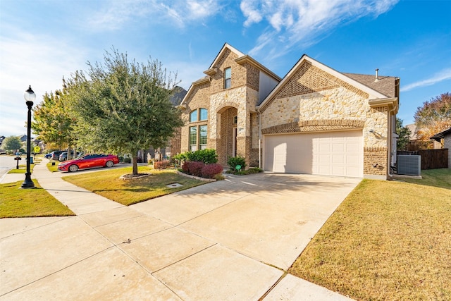 view of front of house featuring central AC, a front yard, and a garage