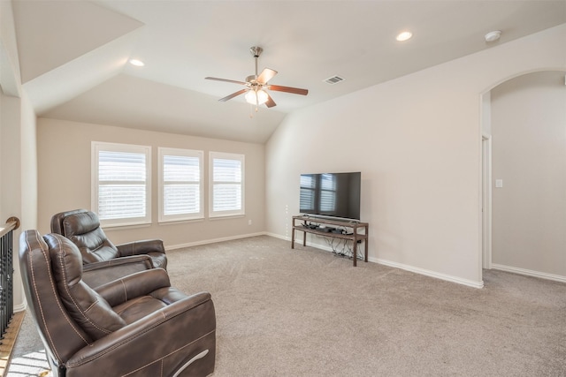 carpeted living room with ceiling fan and vaulted ceiling