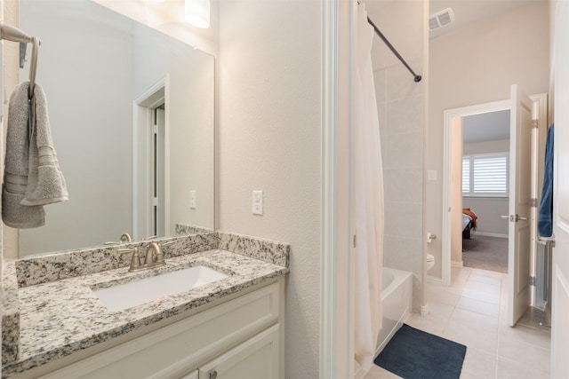 bathroom with tile patterned flooring, vanity, and tiled shower / bath combo