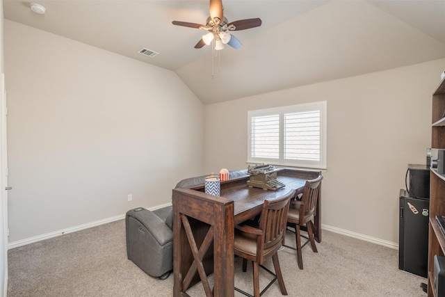 dining area featuring light colored carpet, vaulted ceiling, and ceiling fan