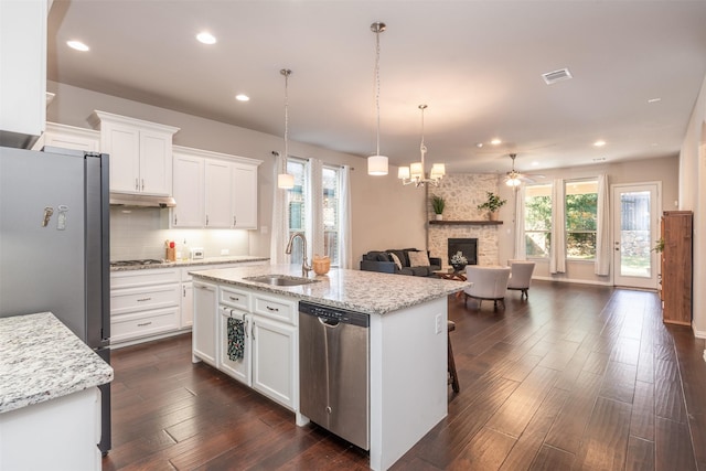 kitchen featuring a healthy amount of sunlight, white cabinetry, sink, and a kitchen island with sink