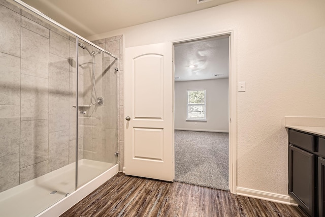 bathroom with vanity, wood-type flooring, and walk in shower