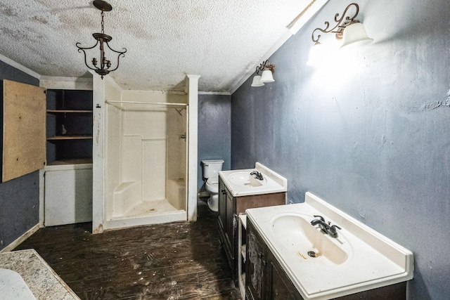 bathroom featuring a shower, vanity, and a textured ceiling