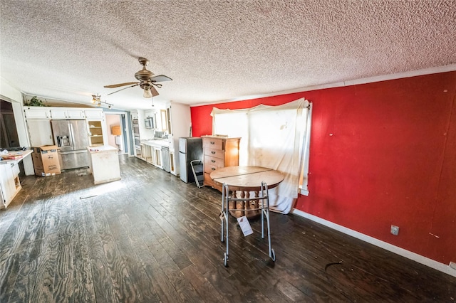 unfurnished dining area featuring a textured ceiling, dark wood-type flooring, and ceiling fan