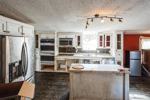 kitchen with stainless steel appliances, white cabinetry, and sink