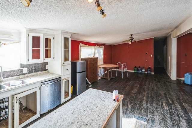 kitchen with appliances with stainless steel finishes, white cabinetry, sink, backsplash, and dark wood-type flooring