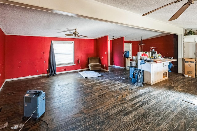 unfurnished living room with dark wood-type flooring, ceiling fan, and a textured ceiling