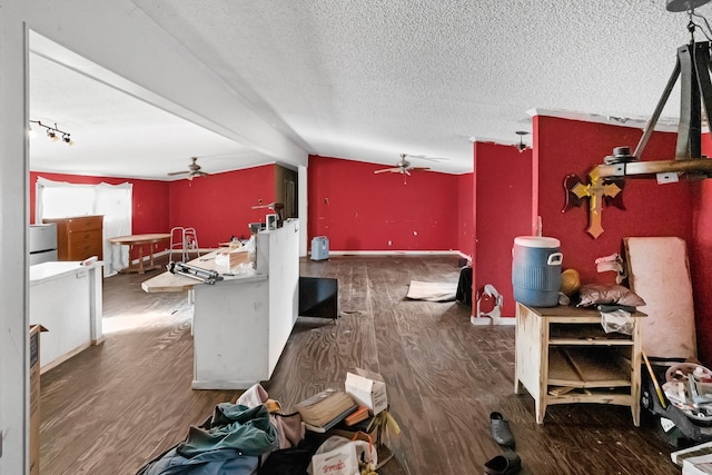 interior space featuring a textured ceiling, dark hardwood / wood-style flooring, vaulted ceiling, and ceiling fan