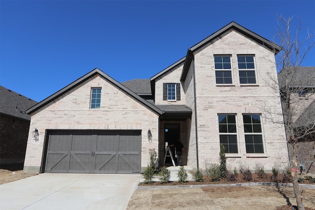 view of front of home with concrete driveway, brick siding, roof with shingles, and an attached garage