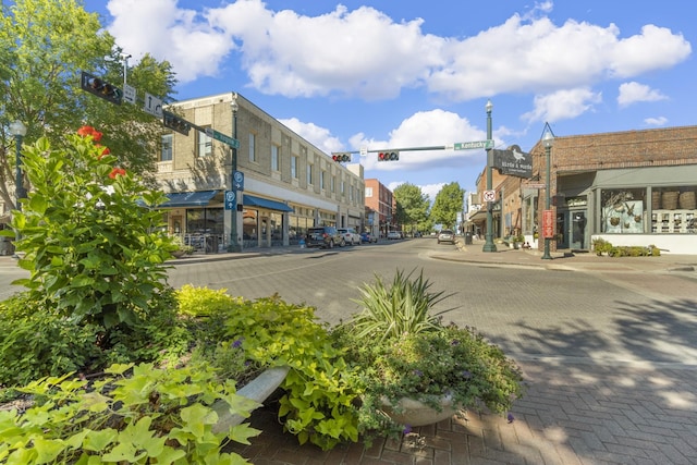 view of street with sidewalks, traffic lights, street lighting, and curbs