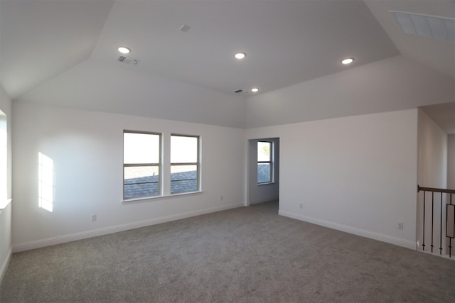 empty room with visible vents, vaulted ceiling, and carpet flooring