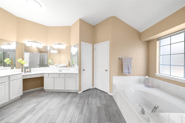 bathroom with plus walk in shower, vanity, and wood-type flooring