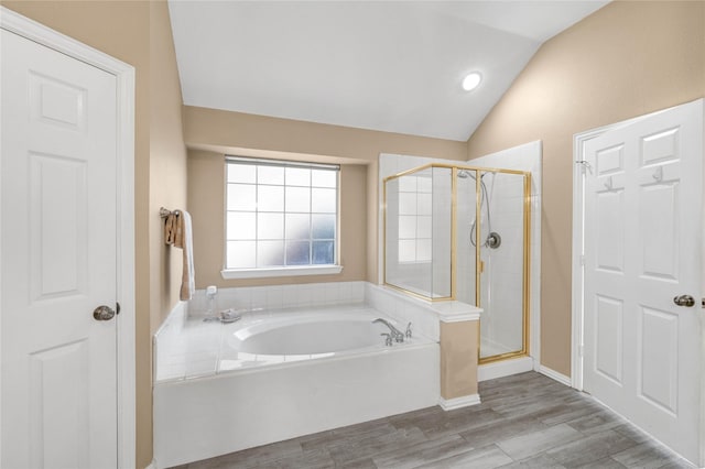 bathroom featuring hardwood / wood-style flooring, vaulted ceiling, and shower with separate bathtub