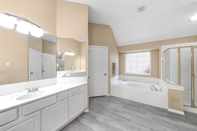 bathroom with vanity, wood-type flooring, vaulted ceiling, and shower with separate bathtub