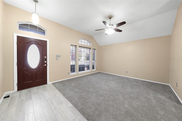 carpeted foyer with ceiling fan and lofted ceiling