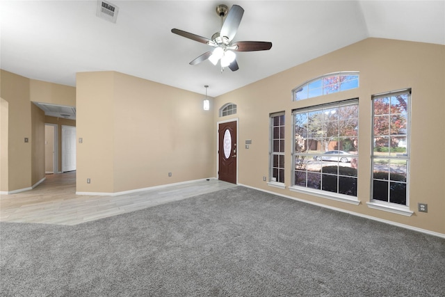 unfurnished living room featuring light colored carpet, vaulted ceiling, and ceiling fan