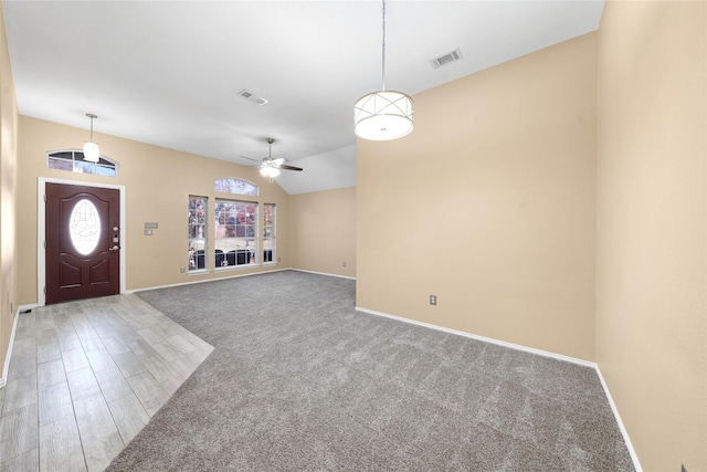 foyer featuring ceiling fan, wood-type flooring, and lofted ceiling