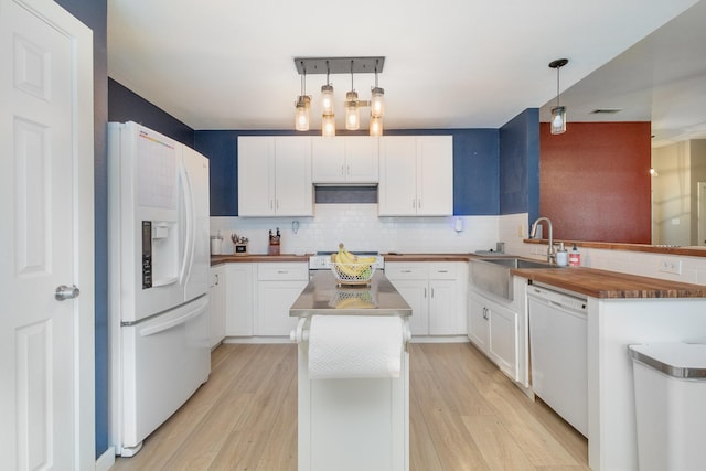 kitchen featuring white cabinets, pendant lighting, white appliances, and light hardwood / wood-style floors