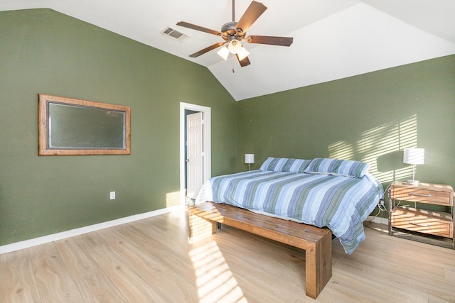 bedroom with ceiling fan, light hardwood / wood-style floors, and vaulted ceiling