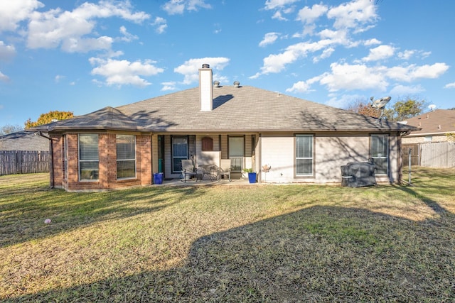 back of property with a lawn and a patio area