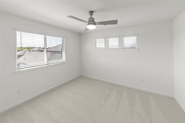 empty room featuring ceiling fan and light carpet