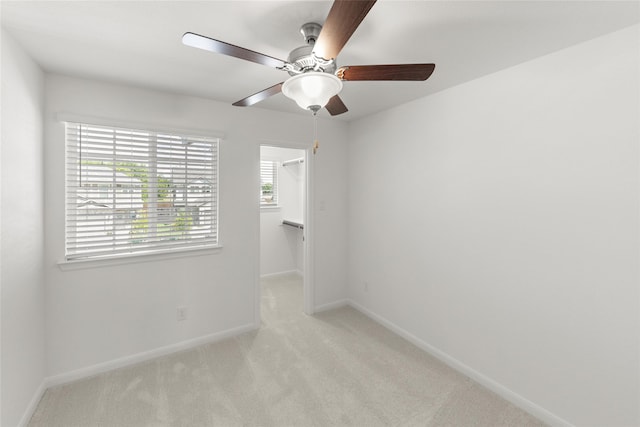 spare room with ceiling fan and light carpet