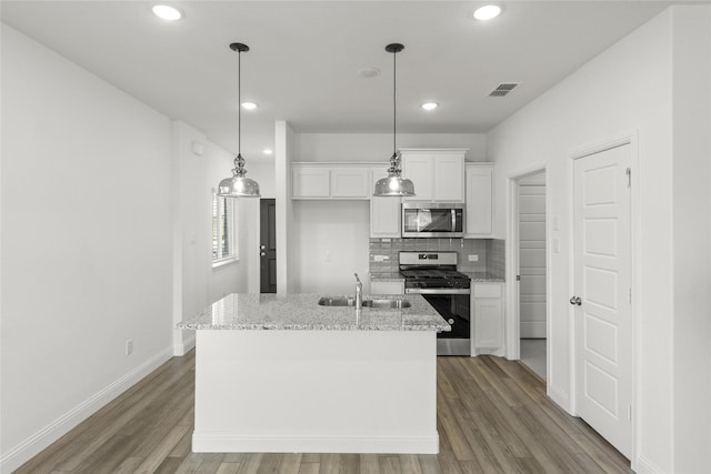 225 Griffith Dr, Princeton, TX 75407 - kitchen featuring appliances with stainless steel finishes, a sink, white cabinetry, wood finished floors, and backsplash