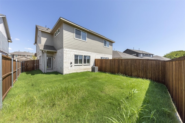 rear view of property with a yard and central AC