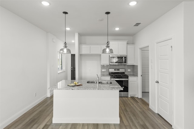 kitchen with appliances with stainless steel finishes, sink, a center island with sink, light hardwood / wood-style floors, and white cabinetry