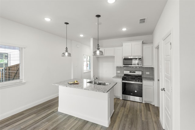 kitchen featuring sink, hanging light fixtures, stainless steel appliances, light stone counters, and white cabinets