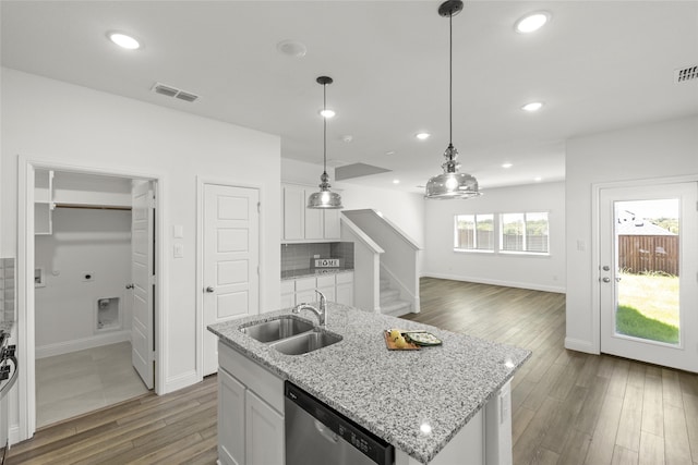 kitchen with sink, white cabinets, hanging light fixtures, stainless steel dishwasher, and a center island with sink