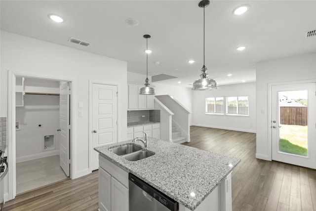 225 Griffith Dr, Princeton, TX 75407 - kitchen featuring stainless steel dishwasher, a sink, white cabinets, wood finished floors, and baseboards