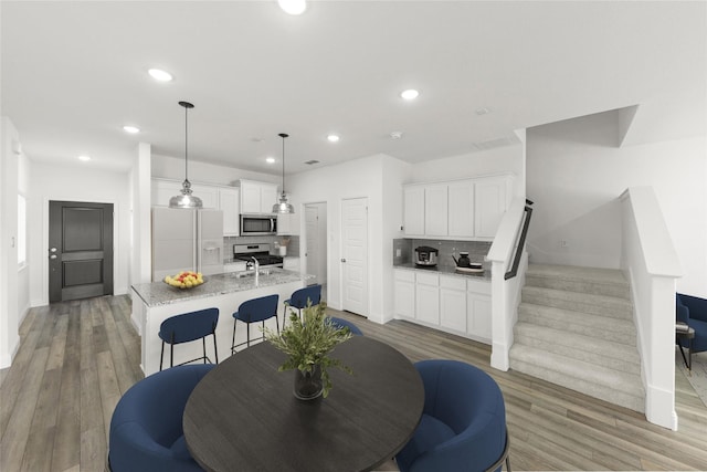 225 Griffith Dr, Princeton, TX 75407 - dining room featuring stairs, recessed lighting, light wood-style flooring, and baseboards