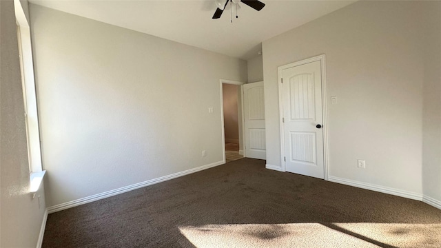 unfurnished bedroom with dark carpet and ceiling fan