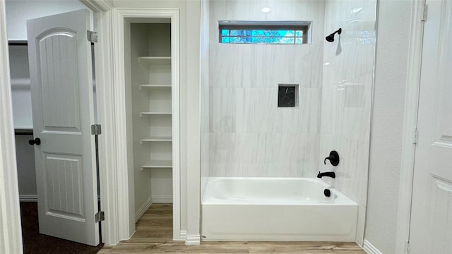 bathroom with hardwood / wood-style flooring and tub / shower combination