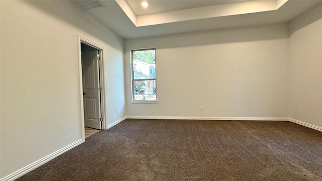 unfurnished bedroom with carpet and a tray ceiling