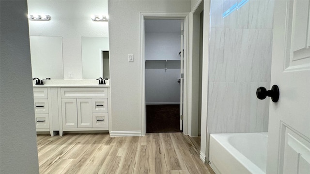 bathroom with vanity, wood-type flooring, and a washtub